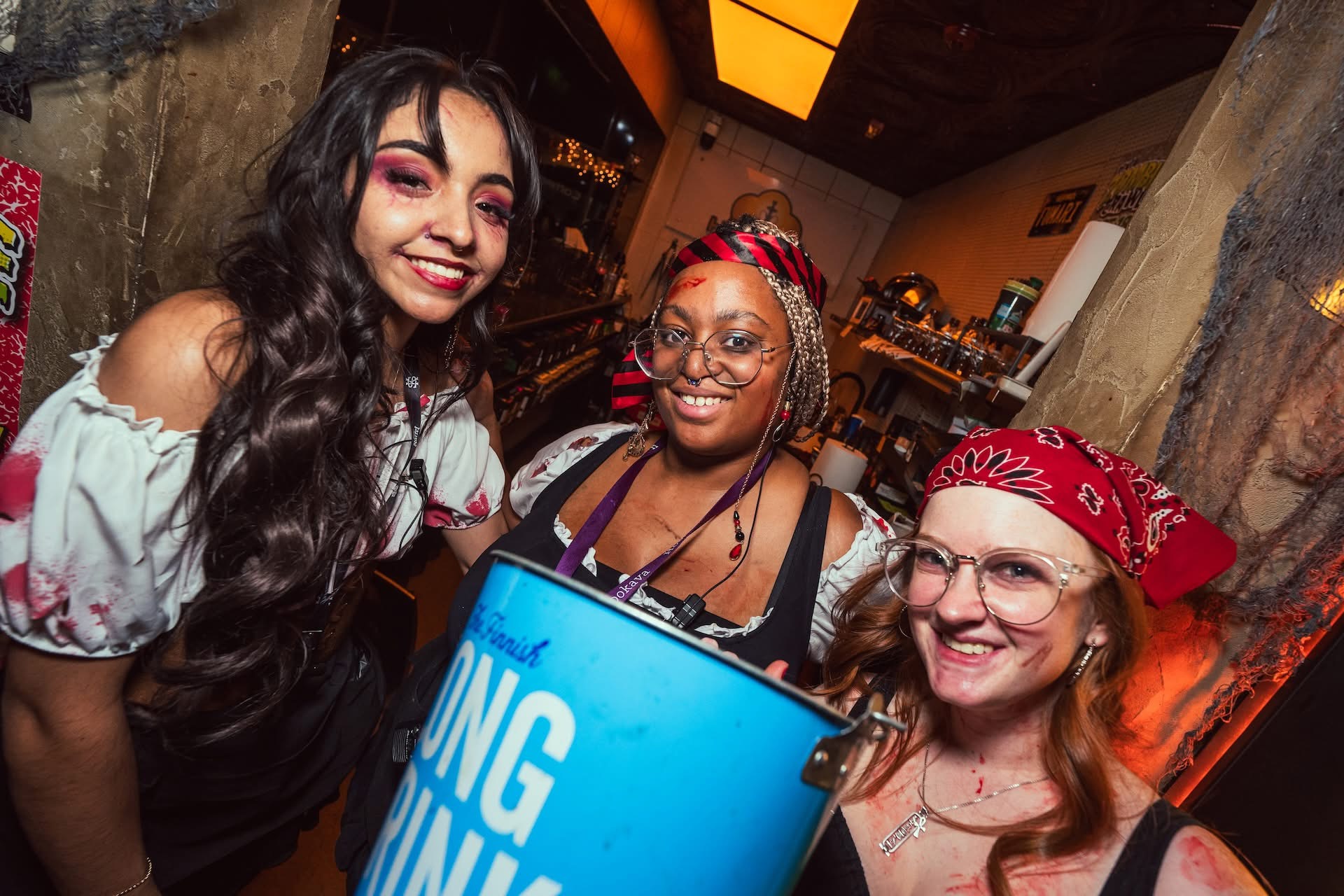 Guests in zombie costumes at Hookava during the Zombie Crawl holding Long Drink buckets